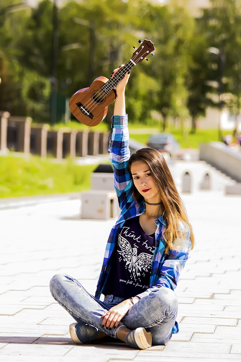 travel, string instrument, ukulele, sitting, portrait of a girl, real people, one person, casual clothing, pavement, front view, beautiful girl, hairstyle
