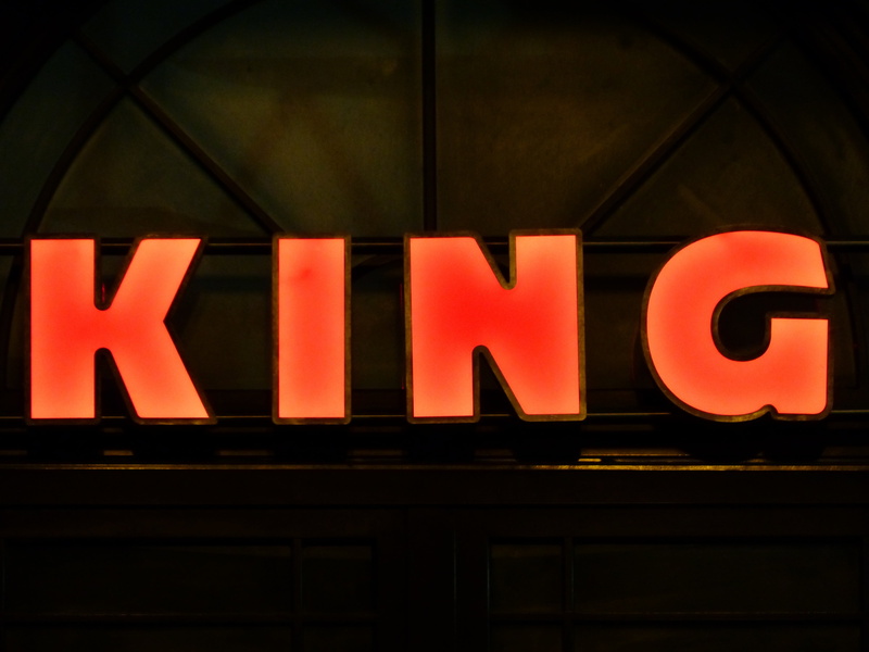 capital letter, orange color, illuminated, text, neon Light, king, neon sign, indoors, shield, red, sign, lighting equipment, low angle view, no people