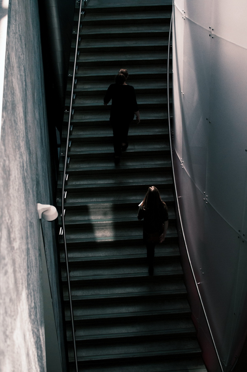 public transportation, adult, obstruction, full length, architecture, walking, window blind, indoors, metal, city, stair, steps and staircases, rear view
