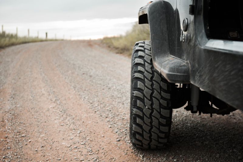 tire, outdoors, dirt, nature, vehicle, agriculture, dirt road, stone, no people, mud, wrangler, transportation, fence, suv, track, motor vehicle, black