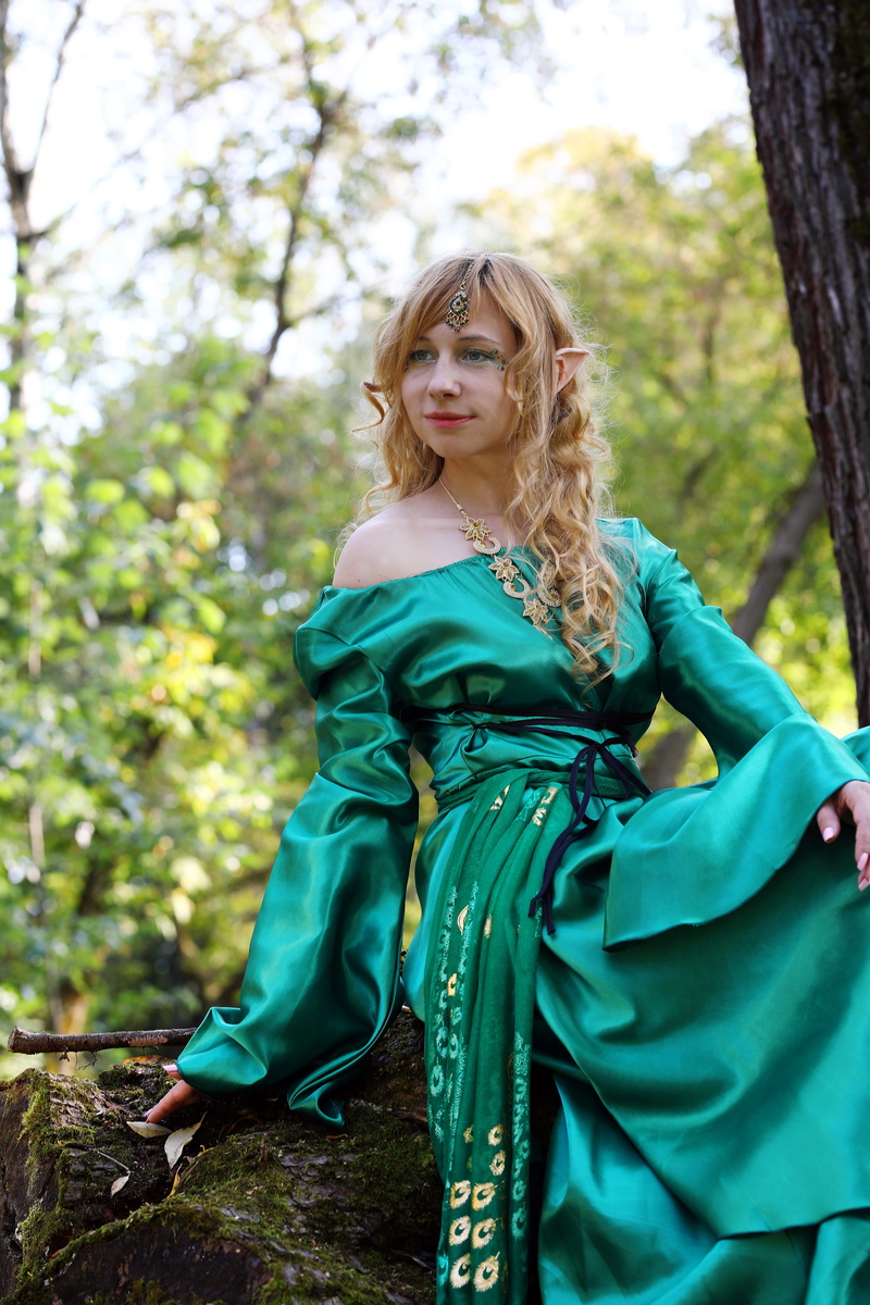princess, beauty, looking at camera, plant, focus on foreground, fantasy, tree, outdoors, hairstyle, fairy, day, fashion, elfika, portrait, green color