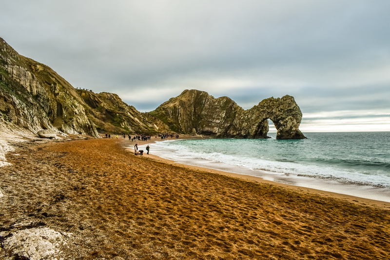 jurassic coast, dorset, outdoors, idyllic, landmark, coastal, tranquil scene, cloud - sky, water, beauty in nature, britain, durdle door, no people, sand