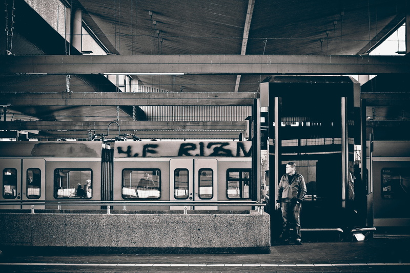 one person, train - vehicle, rail traffic, waiting, grayscale, railway station, connection, lifestyles, front, street photography, public means of transport