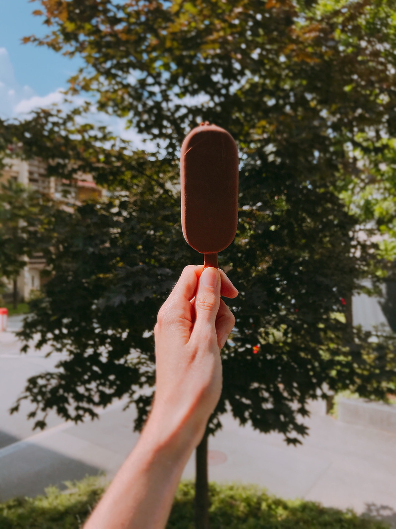 food, 4K, popsicle, body part, day, leisure activity, one person, tree, chocolate, temptation, lifestyles, outdoors, person, personal perspective, summer