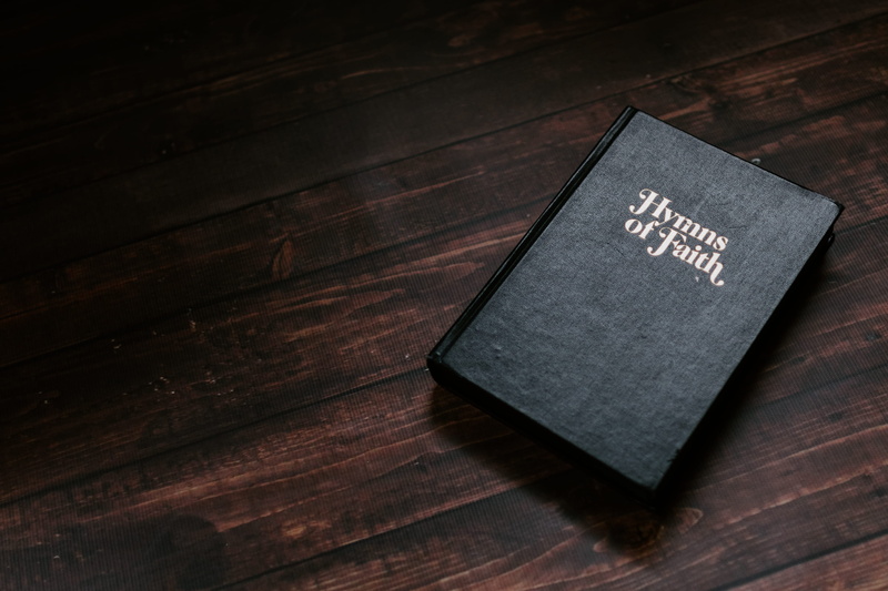 indoors, education, table, publication, book, high angle view, faith, brown, no people, western script, hardcover, communication, wood grain, hyms, church