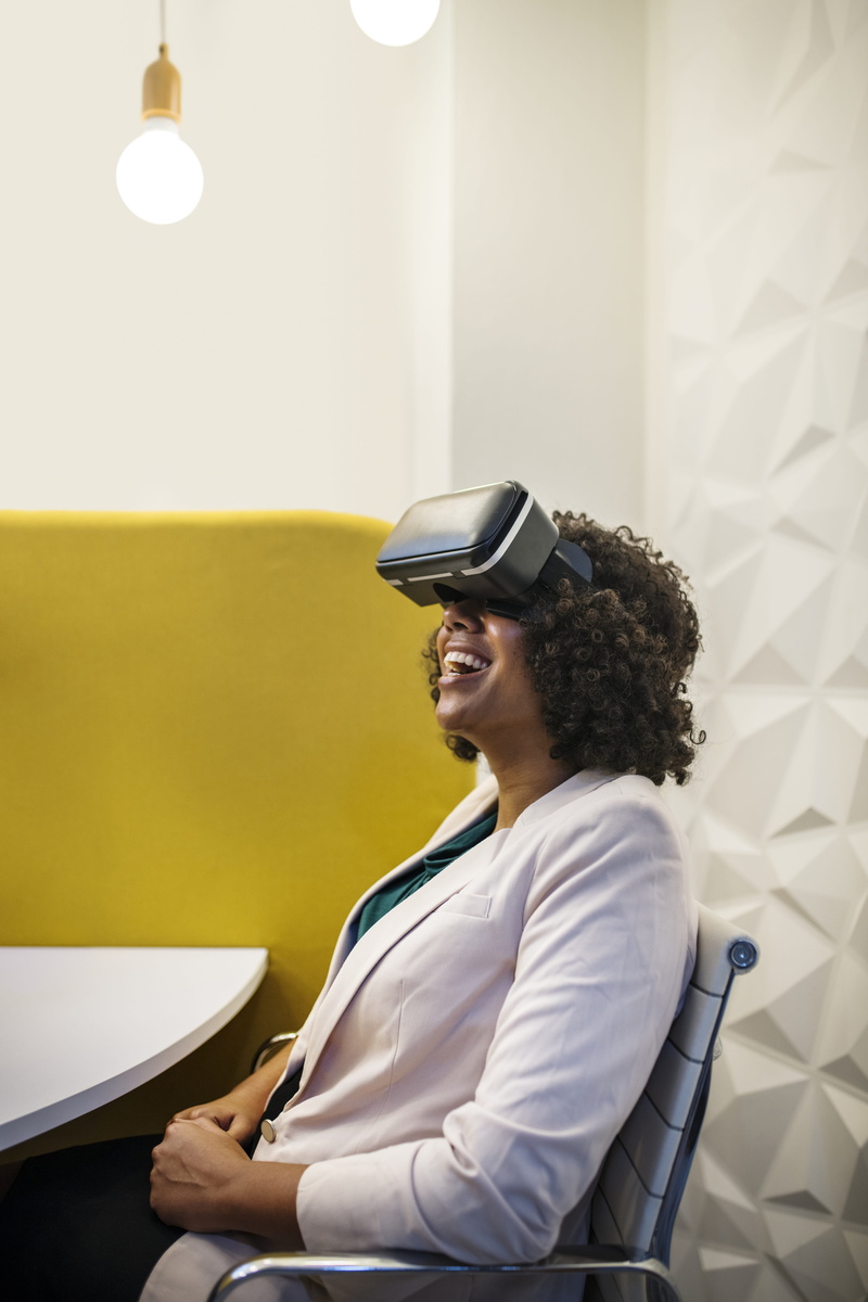 digital, headset, sitting, side view, businesswoman, young adult, indoors, happy, experience, lifestyles, enjoying, casual clothing, leisure activity, smiling