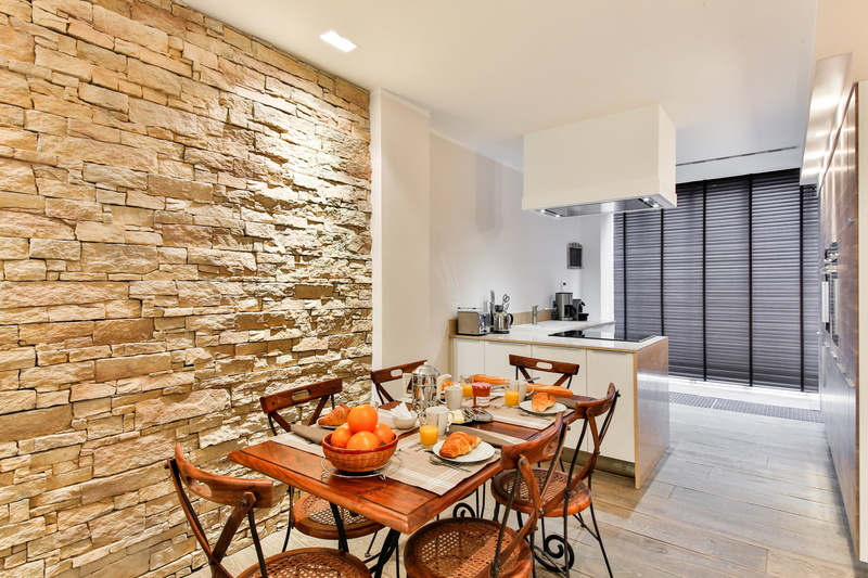 flooring, plate, wall - building feature, modern style, open kitchen, home showcase interior, meal, food, brickwall, stone wall, furniture, indoors, breakfast
