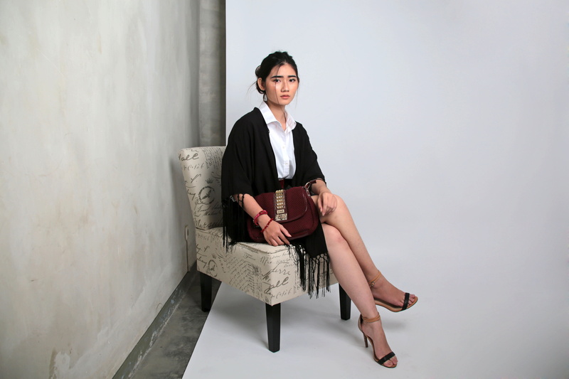 furniture, room, black dress, fashion, blazer, looking at camera, girl, adult, sitting, contemporary, near, shoe, photo studio, walls, wall, beautiful