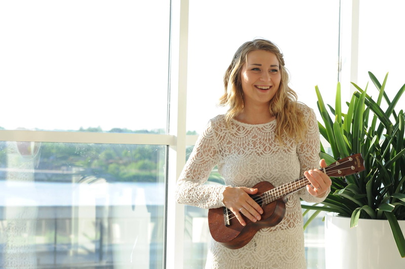 one person, young adult, singing, music, holding, woman, happiness, daylight, smile, musician, enjoyment, hairstyle, blonde hair, fun, happy, plucking an instrument