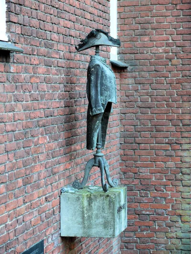 tunic, metal, brass, building exterior, hertogenbosch, art and craft, outdoors, day, pendant, brick, creativity, low angle view, hat, 2K, close-up, statue