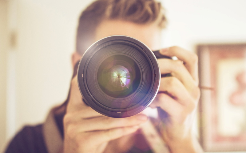 slr camera, zoom, photographer, photographic equipment, bokeh, flare, human body part, camera, focus on foreground, occupation, digital camera, one person