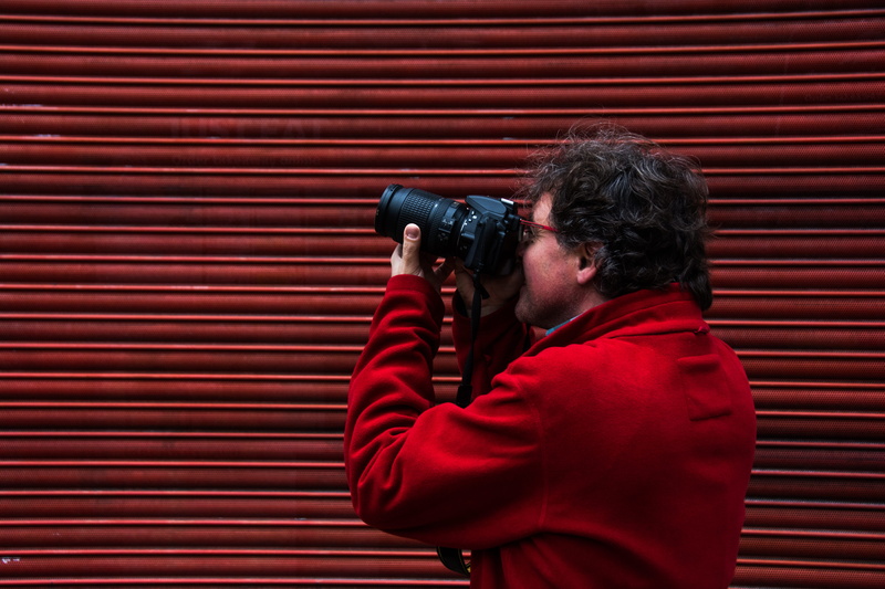 surveillance, caucasian Ethnicity, holding, watching, red, looking through an object, adult, casual clothing, photographic equipment, dslr, occupation