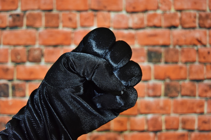 sign, offender, hood, teenager, gloves, wall - building feature, brick, real people, finger, day, men, one person, architecture, fight, s, aggression, hooded shirt