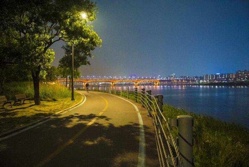 bike, built structure, architecture, clear sky, water, near, time, republic of korea, person, street, transportation, city, tree, illuminated, road, walking