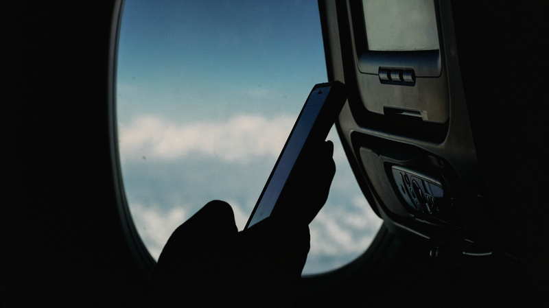 cell phone, transportation, transparent, vehicle interior, smartphone with smartplane, mode of transportation, silhouette, air vehicle, sunlight, outdoors