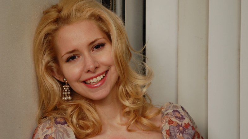 nellie mckay, indoors, white, smiling, toothy smile, wavy hair, shirt, headshot, purple, red, young adult, floral, floral pattern, cheerful, hairstyle