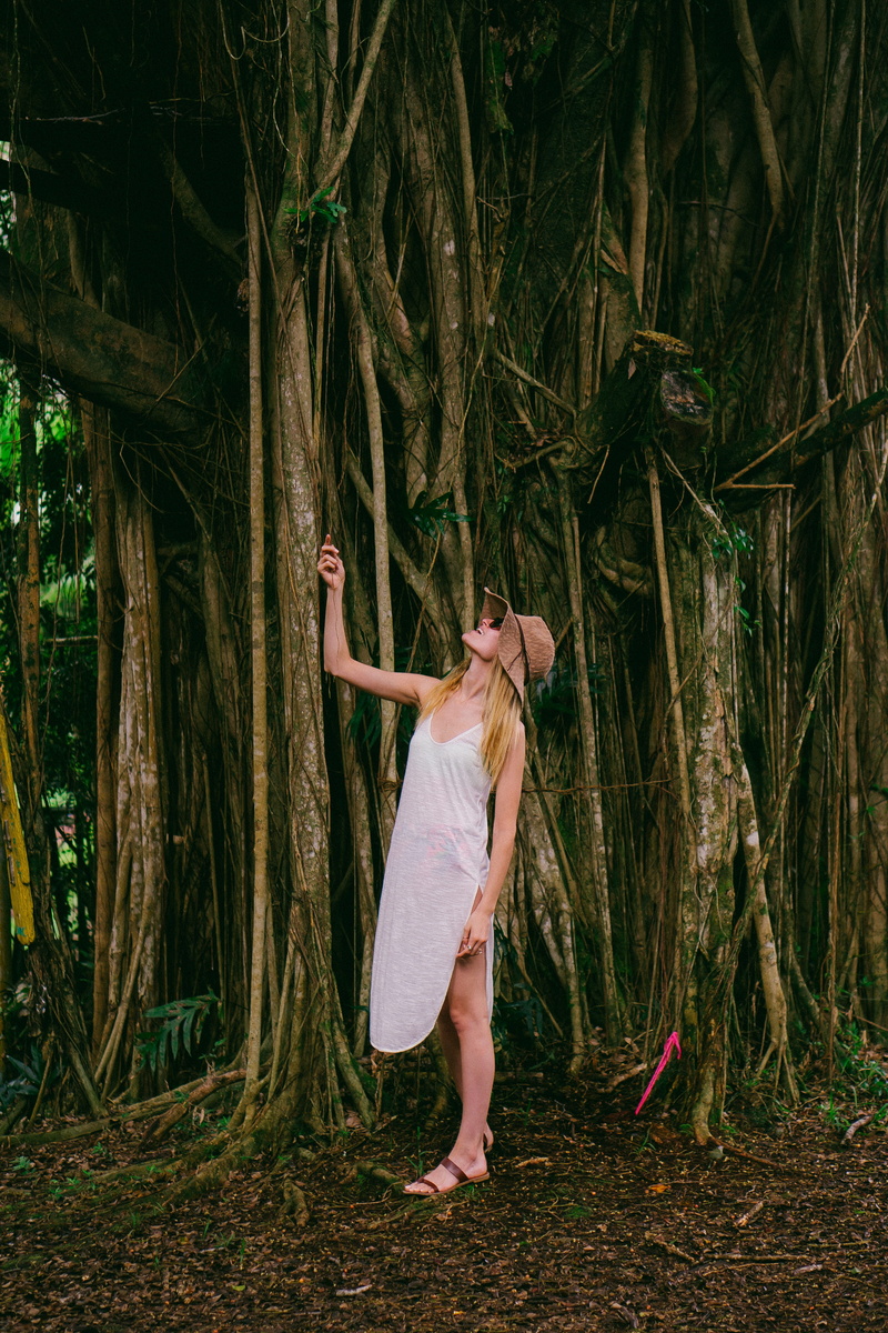 one person, rainforest, human arm, dress, hairstyle, 4K, standing, smile, outdoors, emotion, women, trunk, leisure activity, summer, sunhat, full length