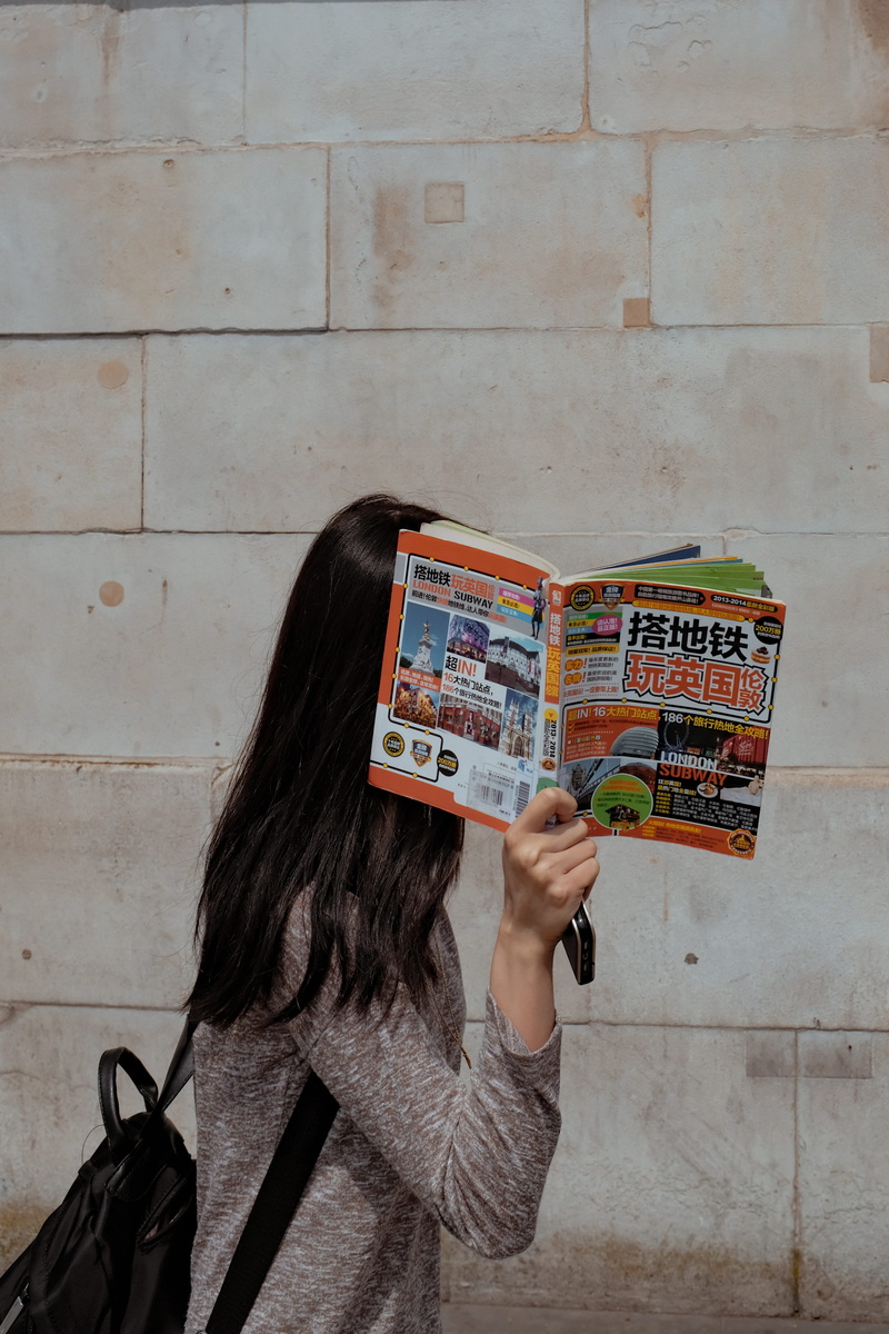 hidden, pedestrian, reading, portrait, indoors, real people, guidebook, london, wearing, concrete, waist up, behind, covering, beside, anonymous, face