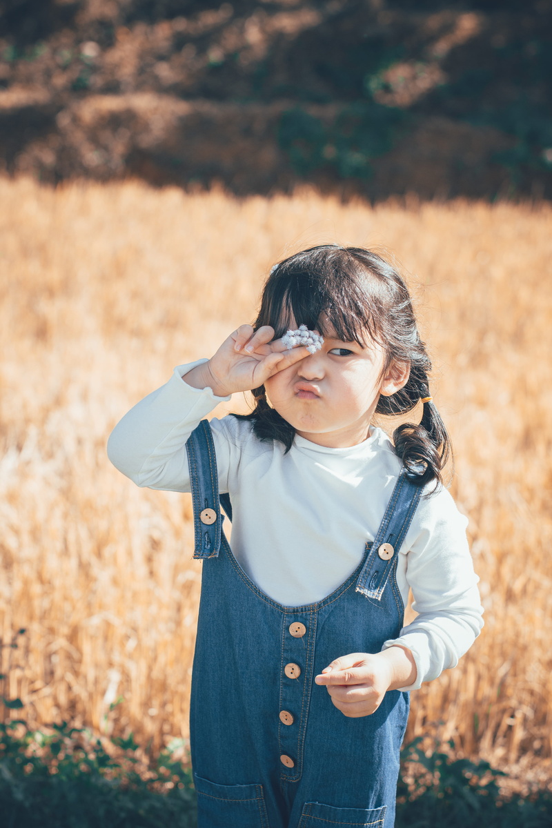 blue, beautiful, innocence, real people, denim, wearing, girl, cute, one person, holding, childhood, adorable, hairstyle, enjoyment, young, smiling, field