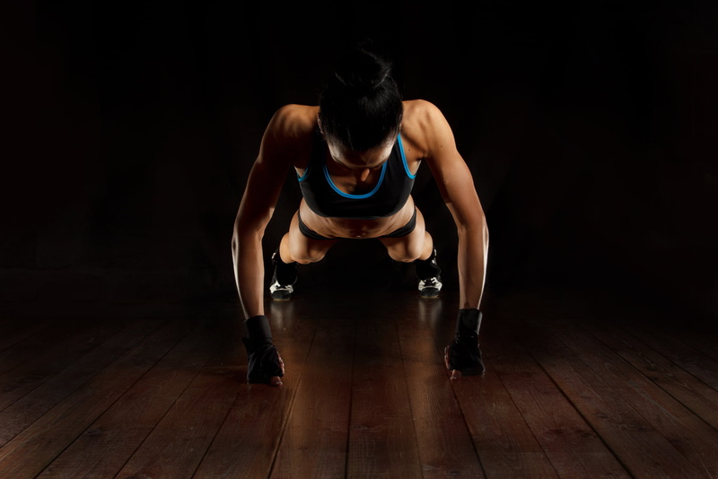 bending, one person, sports clothing, woman, determination, hardwood floor, flooring, front view, clothing, dark, studio shot, sport, adult, hairstyle