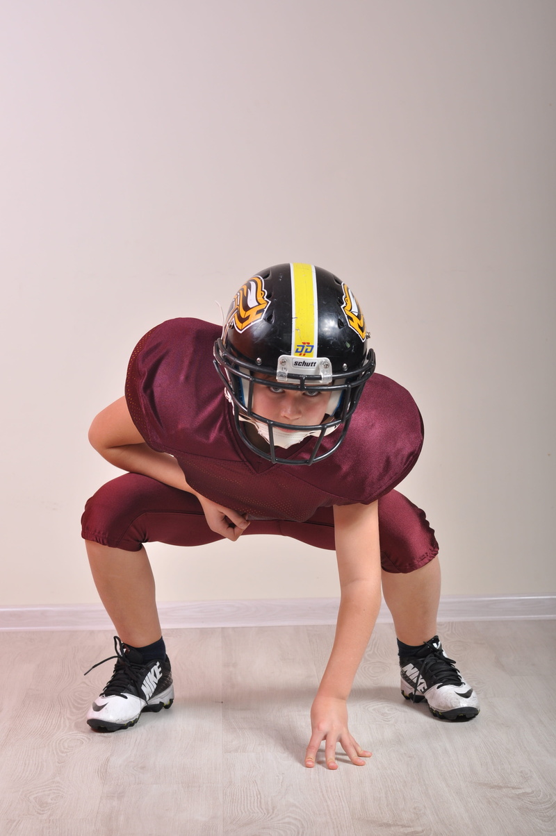 indoors, strength, bending, lifestyles, american, american football, adult, sport, studio shot, soccer ball, one person, holding, occupation, blow, exercising