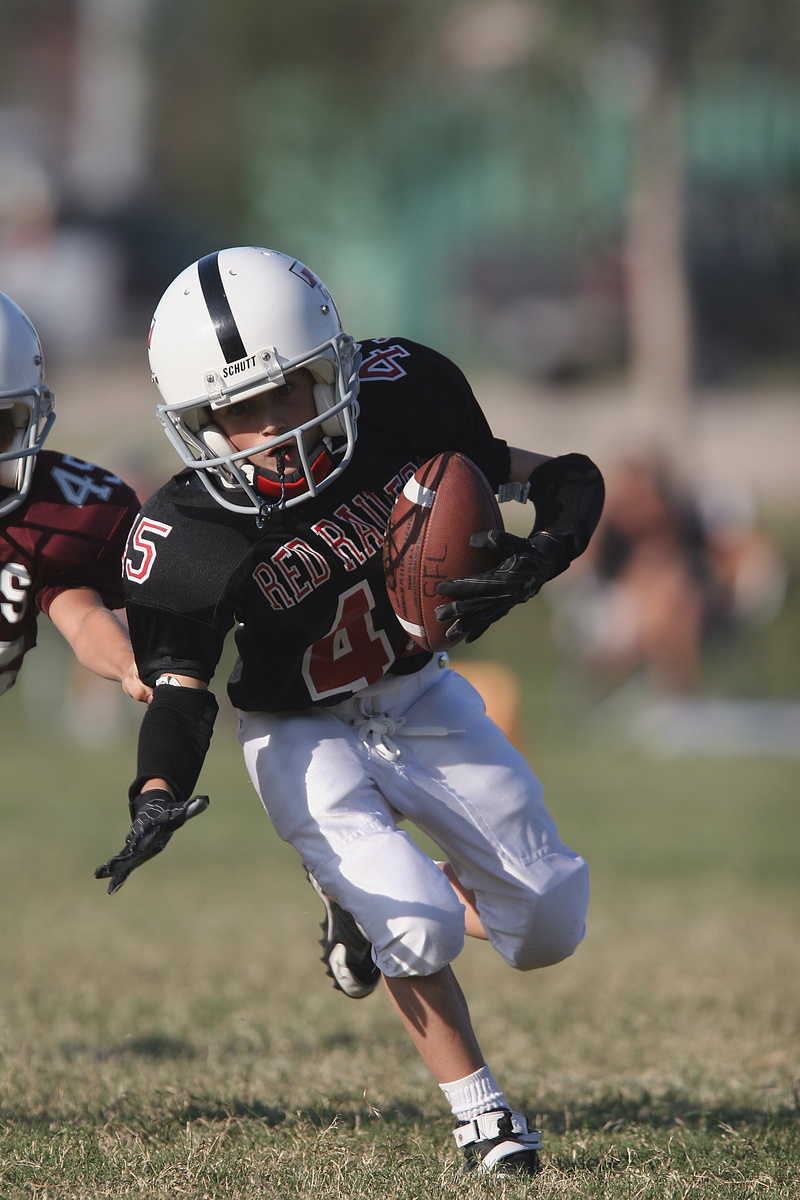 protection, competing, determination, incidental people, grass, ball carrier, headwear, child, athletic, ball, action, sport, playing, game, athlete, defending