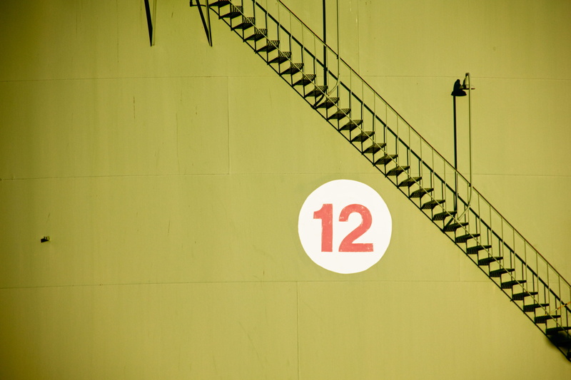 red, railing, staircase, communication, no people, near, yellow, indoors, day, text, wall - building feature, shadow, city, information, number, white