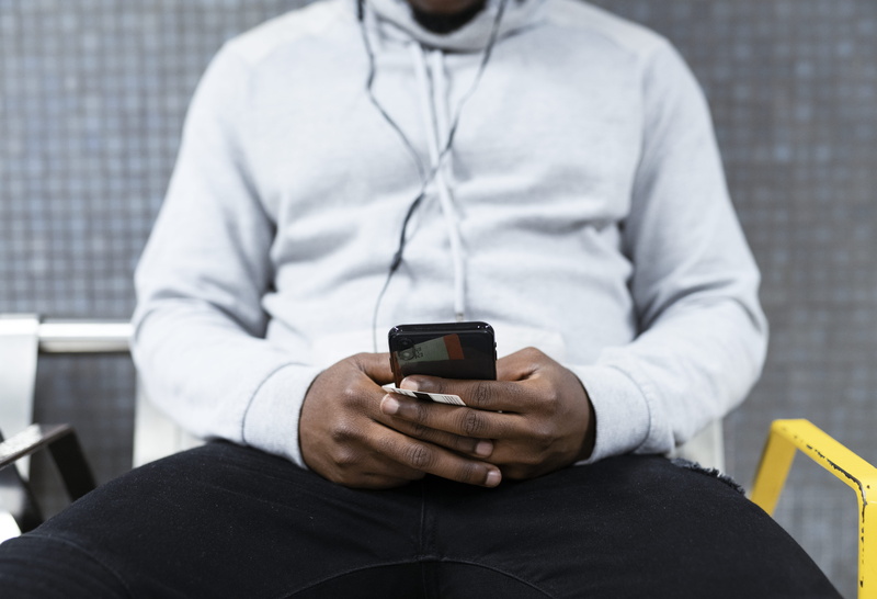 blur, midsection, metro, hoody, real people, 8K, music, underground, one, underground station, holding, text messaging, headphones, indoors, gray, men