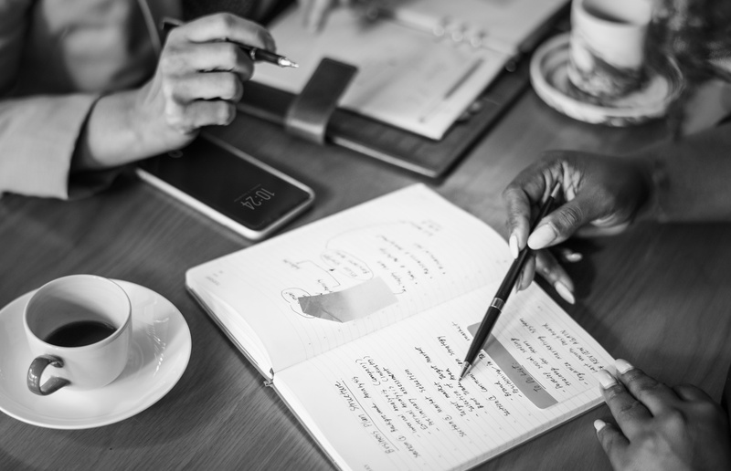 pen, coffee - drink, gray scale, book, human body part, cup, correspondence, table, digital device, mug, holding, communication, financial, closeup, publication
