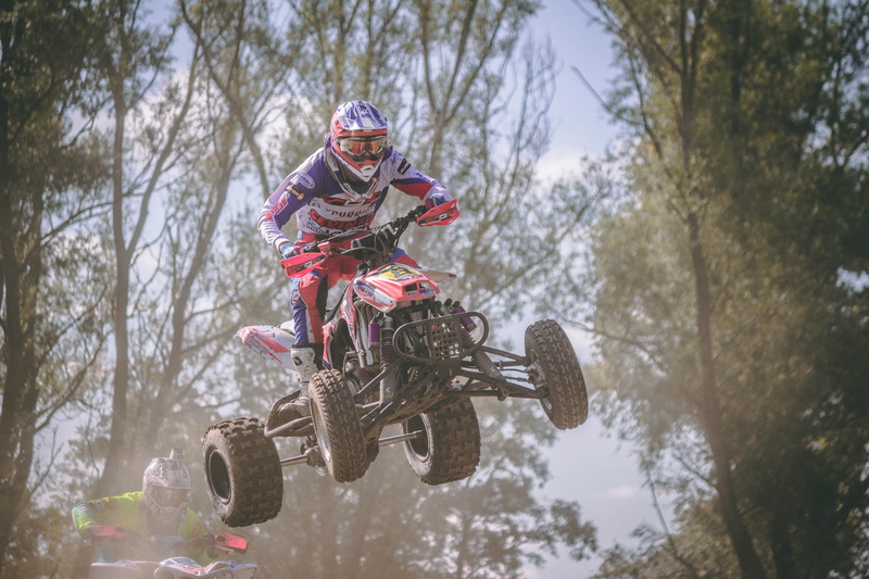 bike, trees, adult, red, tree, headwear, low angle view, athletic, outdoors, quad, dirt bike, sport, jumping, real people, airborne, nature, quad biking