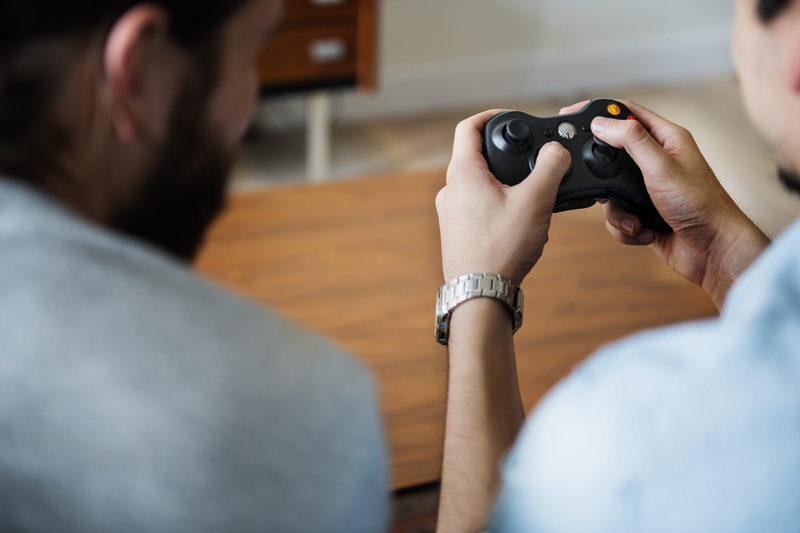technology, fun, headshot, game controller, wireless, gamepad, analog, camera - photographic equipment, focus, men, concentration, over the shoulder view