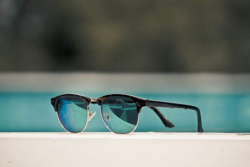 blue, spectacle, sunglass, clubmaster, pool, eyeglasses, white, focus on foreground, outdoors, surface, swimming pool, black, land, water, vacations, framed