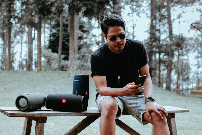 electronics, accessory, smartphone, beside, wireless technology, phone, outdoors, using, footwear, person, tree, young adult, sunglasses, technology, leisure activity