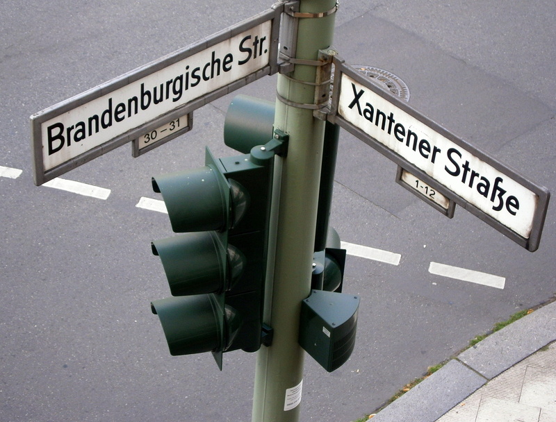 street, text, outdoors, communication, crossing sign, traffic light signals, road sign, warning sign, traffic signal, traffic lights, street name, no people