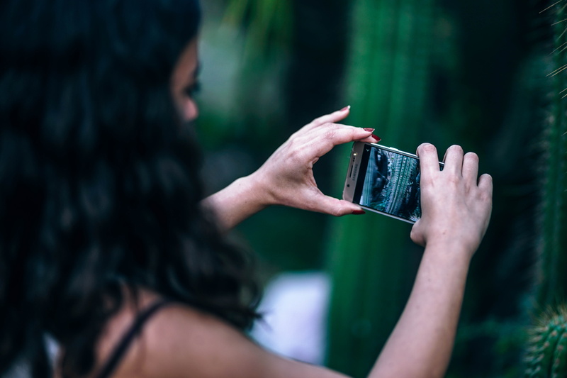 one person, portrait, mobile phone, phone, focus on foreground, girl, portable information device, smart phone, cellphone, hair, close-up, adult, hairstyle