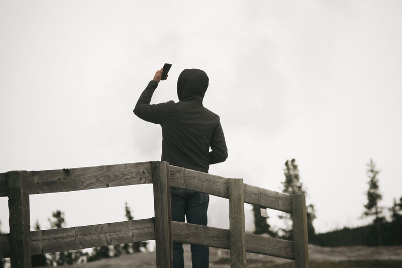 black, wearing, standing, platform, one Person, copy Space, three quarter length, phone, nature, aggression, hoodie, wood - material, photographing, adult