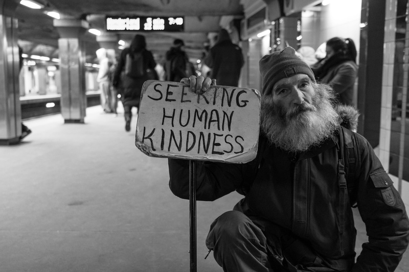 signage, city, men, man, text, holding, station, kindness, male, 5K, incidental people, human, western script, focus on foreground, card, real people