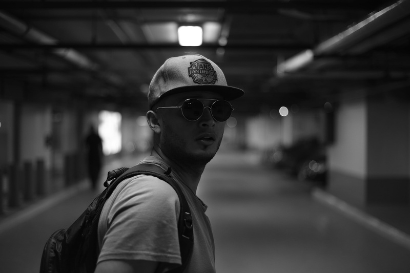 subway system, 2K, glasses, cap, built structure, travel, person, adult, action, eyewear, standing, backpacking, sign, modern, wear, men, focus on foreground