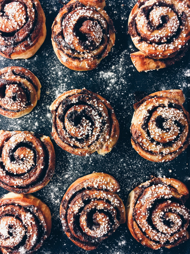 brown, cinnamon, freshness, large group of objects, close-up, rolls, muffin, pastry, directly above, powdered sugar, pastries, black, baked, snack, no people