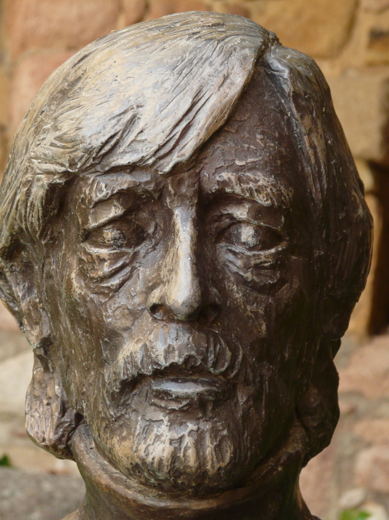 representation, focus on foreground, outdoors, male likeness, close-up, no people, portrait, metal foundry, spirituality, art, angel, 2K, day, stone material
