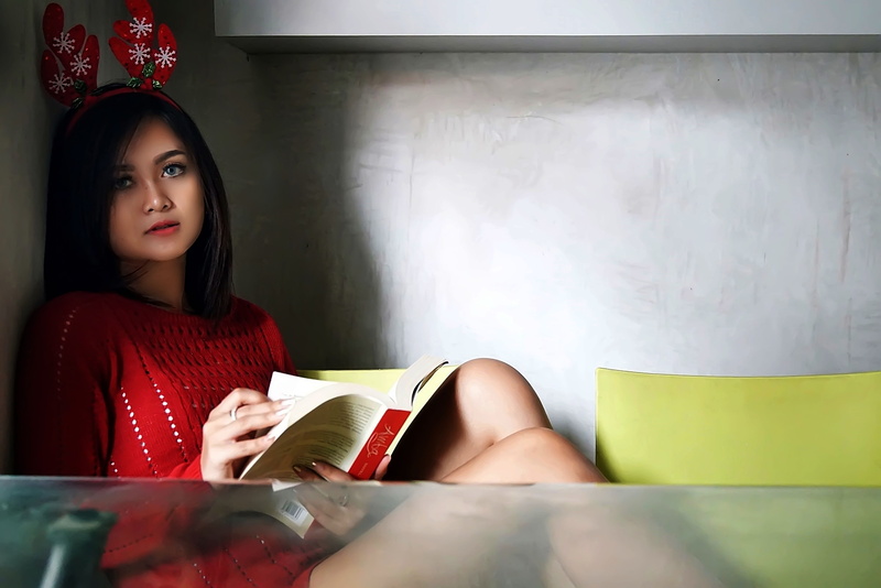indoors, model, young women, hairstyle, magazine, sitting, headwear, one person, female, photo, front view, red, facial expression, red dress, reading