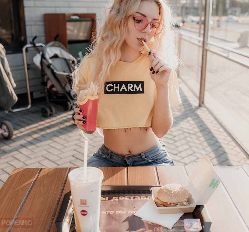 women indoors, sitting, French fries, belly, Andrey Popenko, jeans, tattoo, table, hamburgers, women, blonde, black nails, glasses, 1080P, T-shirt