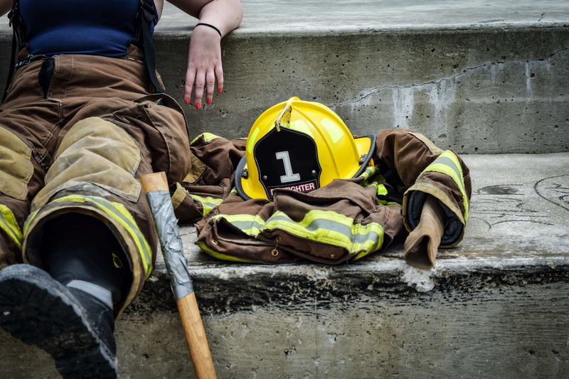occupation, safety, outdoors, career, resting, jacket, lifestyles, uniform, real people, sit, men, water, protection, two people, firewoman, helmet, professional
