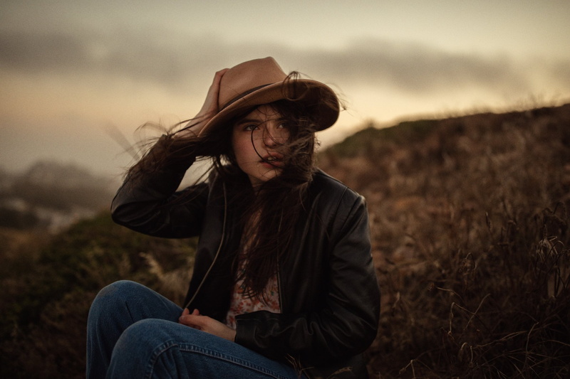 casual clothing, one person, leisure activity, clothing, hairstyle, land, sunset, women, environment, cowboy hat, nature, three quarter length, field, contemplation