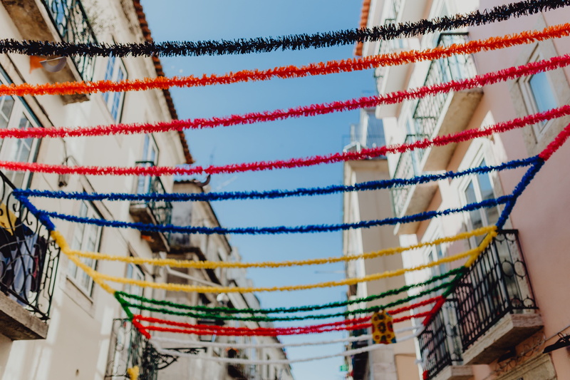 multi colored, focus on foreground, lisbon, white color, no people, saint, hanging, blue, arts culture and entertainment, low angle view, town, decorations