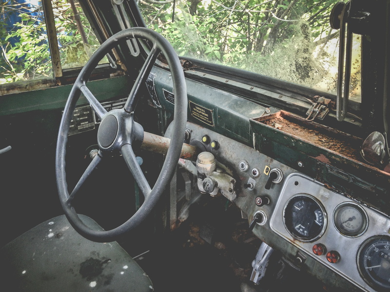 land vehicle, metal, day, tree, car, trees, truck, cockpit, indoors, dashboard, no people, abandoned, control, green, mode of transportation, automotive