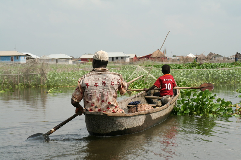 canoeing, rear view, day, fisherman, waterfront, river, transportation, fishing boat, lifestyles, men, benin, built structure, real people, nautical vessel