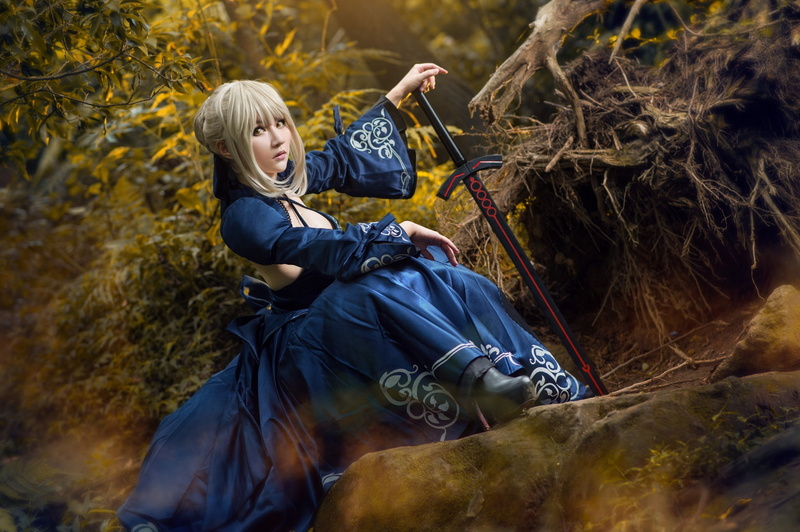 blonde, bangs, face, hands, sword, style, foliage, look, 1080P, cosplay, pose, sitting, roots, girl, hairstyle, stones, blue dress, forest, weapons, blue
