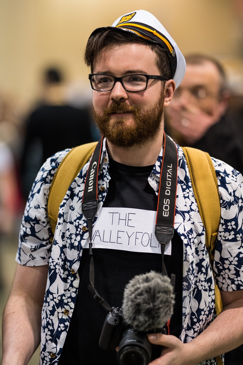 beard, electronics, sleeve, accessories, clothing, indoors, musical instrument, camera, two people, man, glasses, looking at camera, front view, hair, musician