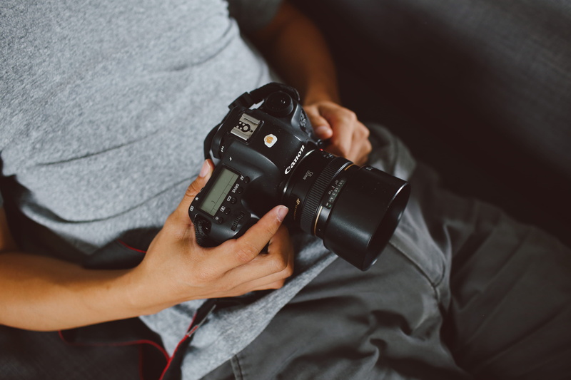 selfie, photographic equipment, glasses, camera, gray, dslr, midsection, shirt, focus on foreground, camera - photographic equipment, holding, video camera